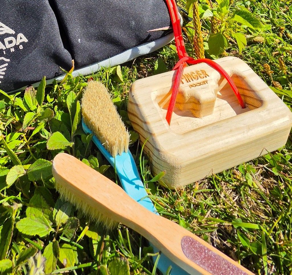 Cepillos de escalada y tabla Finger Pocket sobre el pasto